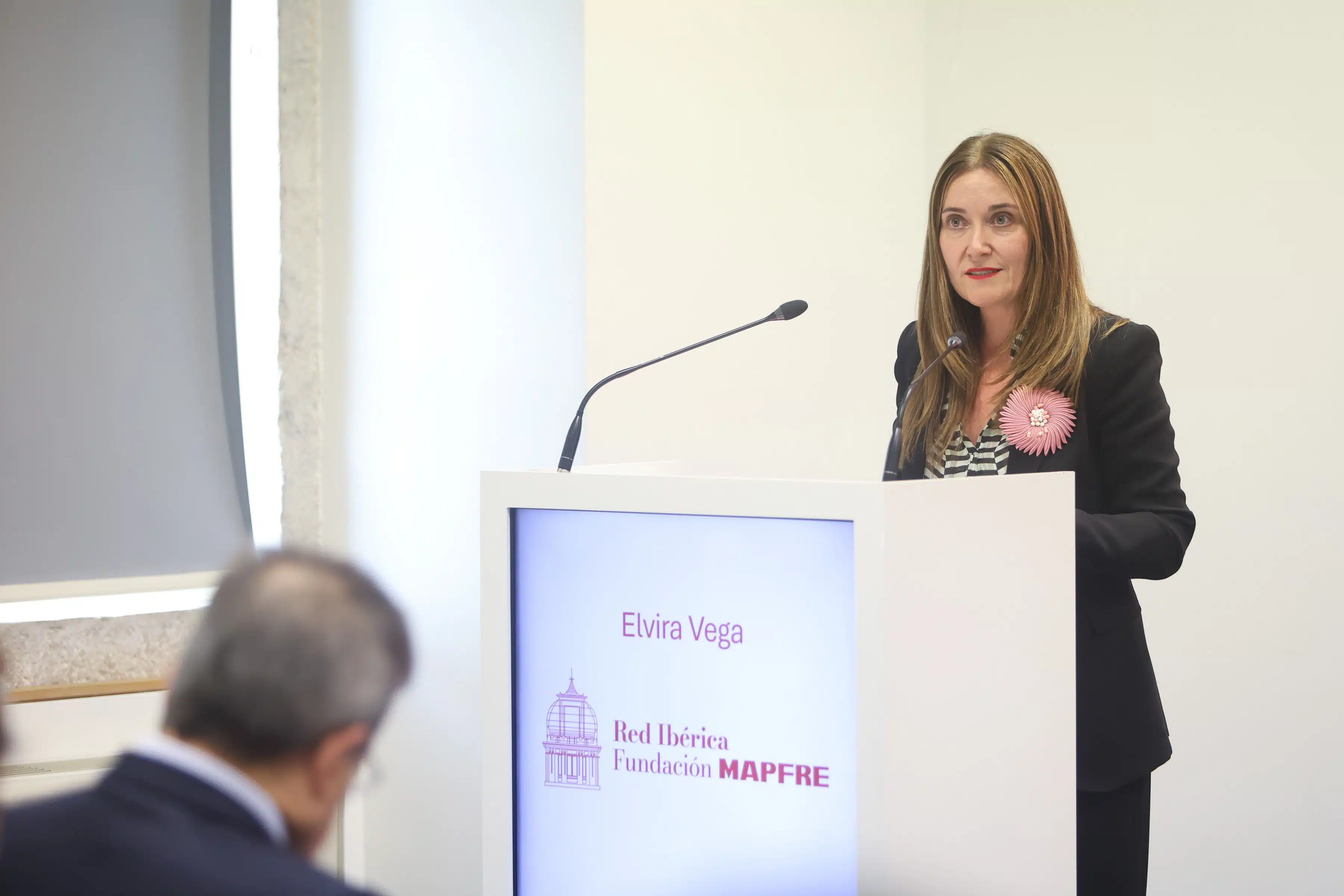 Elvira Vega, diretora geral da Fundacíon MAPFRE, diante de um púlpito a discursar.