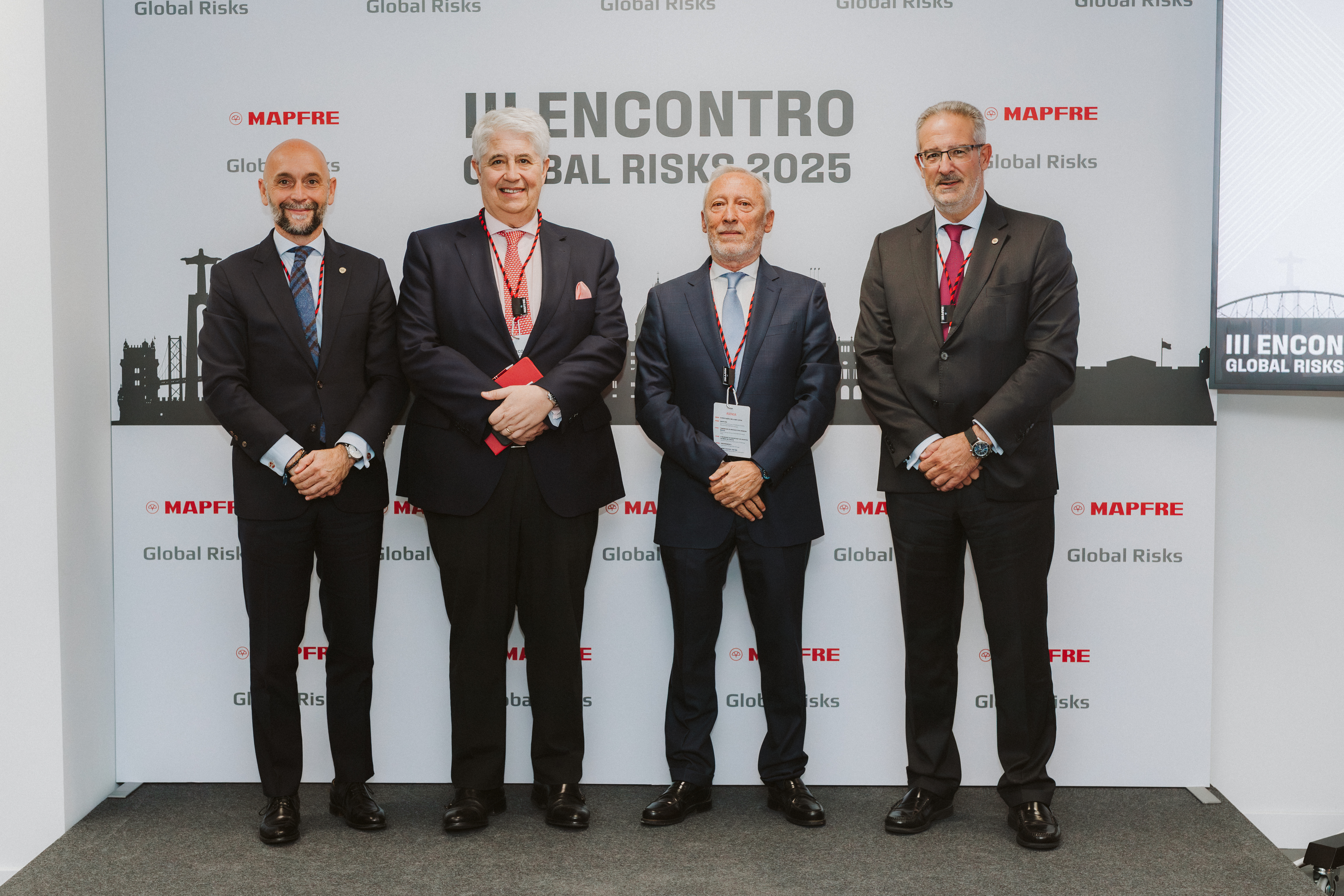 Três representantes da MAPFRE, da MAPFRE Global Risks e um historiador posam em frente ao painel do III Encontro Global Risks 2025, durante um evento dedicado à discussão dos Grandes Riscos, realizado em Lisboa.
